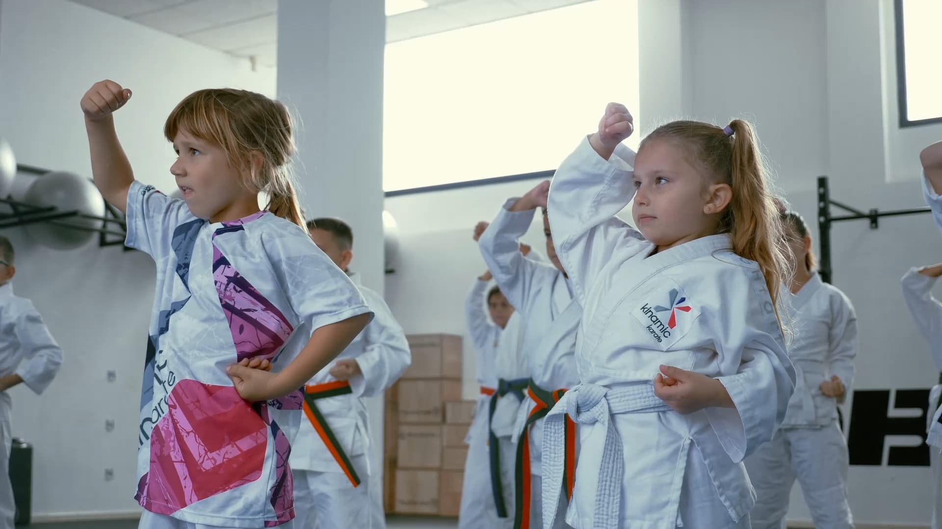 Clase infantil practicando técnica de bloqueo en el dojo Kinamic